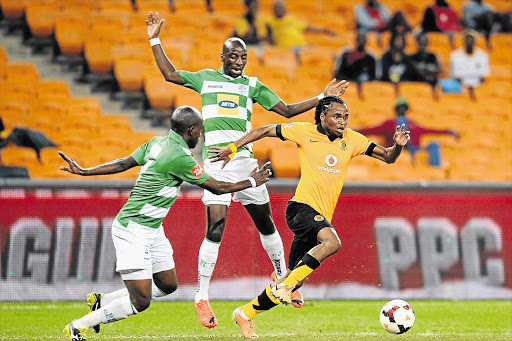 LIKE A HOT KNIFE THROUGH BUTTER: Diminutive Siphiwe Tshabalala of Kaizer Chiefs dribbles past Bloemfontein Celtic's towering defenders Musa Nyatama and Tsietsi Mahoa during the teams' Absa Premiership match at FNB Stadium last night. Amakhosi won 3-0