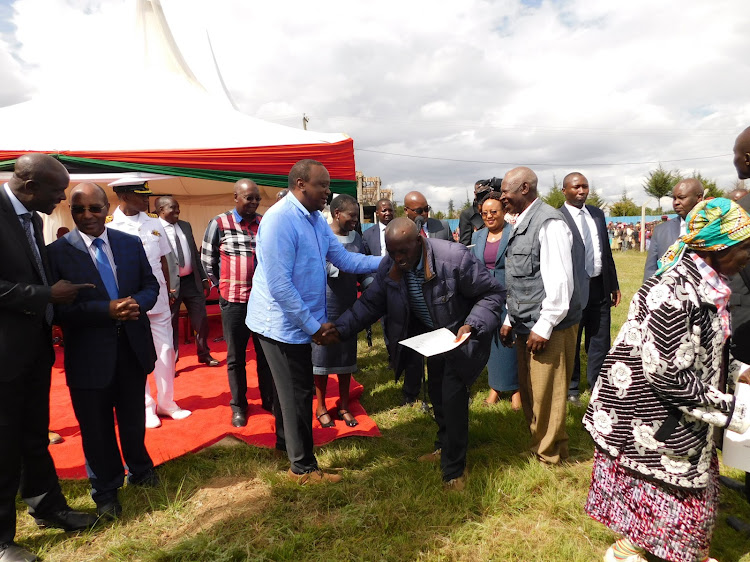 President Uhuru Kenyatta issues title deeds to Nyandarua colonial villages dwellers on Friday.