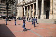 Members of the police do foot patrols near the Gauteng Legislature, 20 March 2023, in the Johannesburg CBD. The area is quieter than usual with many businesses closing their doors amid fears of protests in the CBD by the EFF.