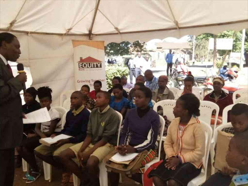 Eight beneficiaries of Equity Bank's Wings to Fly scholarship programme are advised by Kutus branch manager Macharia Gakiri, December 28, 2017. /GEOFFREY KIBISU