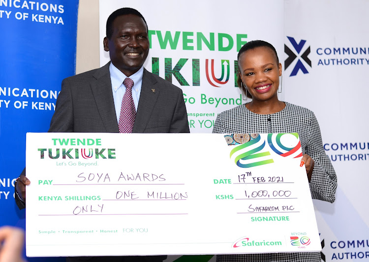 SOYA founder and NOC-K president Paul Tergat receives a dummy cheque from Safaricom's Peris Nduta for the awards to be held on Saturday.