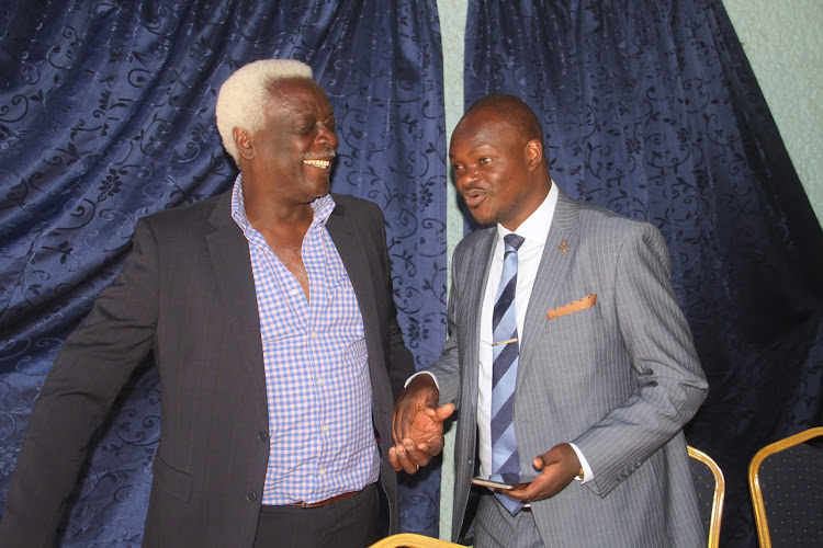 Former Harambee Stars defender Bobby Ogolla shares a light moment with Kenya Soccer Players Association (KSPA) secretary general Harold Ndege during a press briefing at a Nairobi hotel