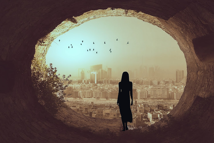 A woman stands in front of the Dubai skyline