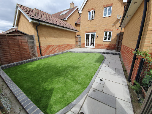 Kandla grey sandstone with charcoal boarder and flower bed, artificial grass all completed by smartcraft Landscapes 