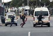 A police officer pursues two vagrants on foot in the Durban CBD on Wednesday.