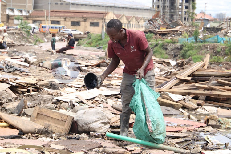 A man salvages items after demolitions at Mukuru kwa Njenga on May 6, 2024.