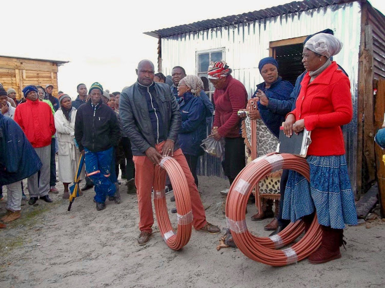 Residents of Siyahlala informal settlement in Khayelitsha prepare to install their own water taps