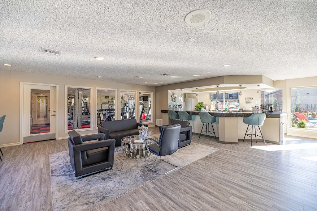 Clubhouse kitchen and seating area, next to fitness center, with wood plank flooring and contemporary decor