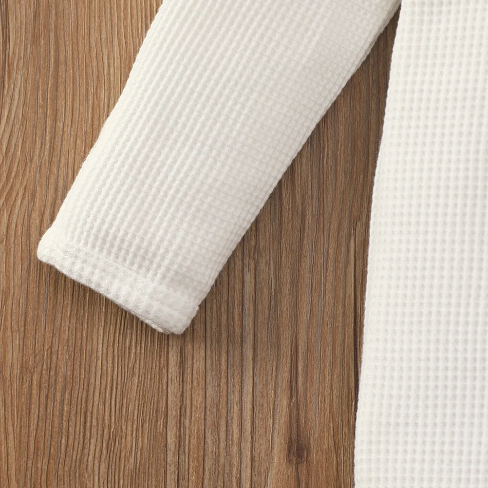 Barboteuse en waffle unie à manches longues et fermeture éclair pour bébés garçons et filles, avec pieds intégrés, pour un confort optimal et douillet.