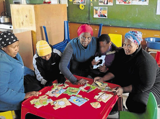 HELPING HANDS: Sibanye Day Care Centre founders Veliswa Mdaka, centre, and Nomalungisa Maloni, right, with volunteer Nontle Mdoko and two of the children Picture: DAVID MACGREGOR