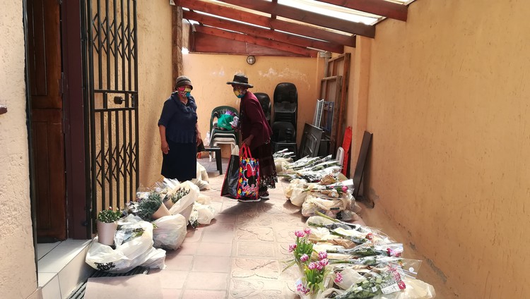 Pensioner Leah Mtshali collects her food parcel and a bouquet of flowers from Sylvia Mvumvu’s home in Alexandra, Johannesburg.