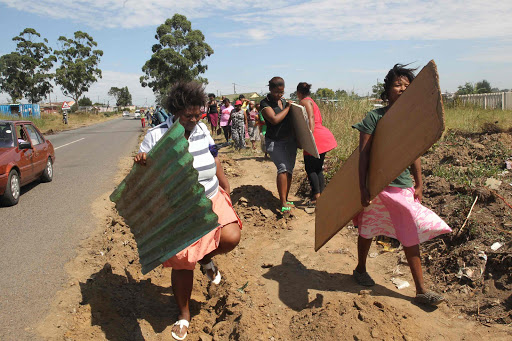 DEFIANT: Residents of Ndancama Squatter camp in Scenery Park, who were chased away by metro police, are rebuilding their homes once again Picture: MICHAEL PINYANA