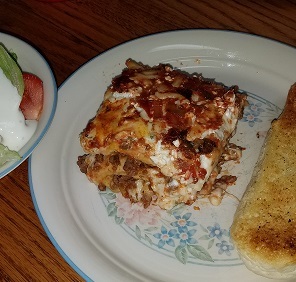 Lasagna with a green salad and garlic bread