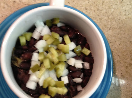 Cuban Black Bean soup garnished with onions and chopped pickles