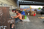 Tyson Morlock plays piano next to a swimming pool hooked to a fire hydrant under a freeway underpass during a heatwave in Portland, Oregon, US, June 29, 2021.  