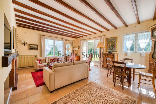 Bright living room with exposed beams and fireplace in this luxury property for sale in Breuillet ($931,817 - 260 m²)