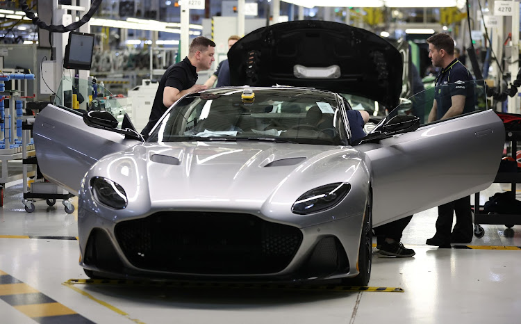 Employees work on a car at the Aston Martin factory in Gaydon.