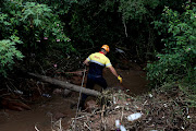 Search and rescue members look for Zandile Magwaza,30, believed to have been swept away by floods while sleeping at home in Kwa-Santi, Pinetown.