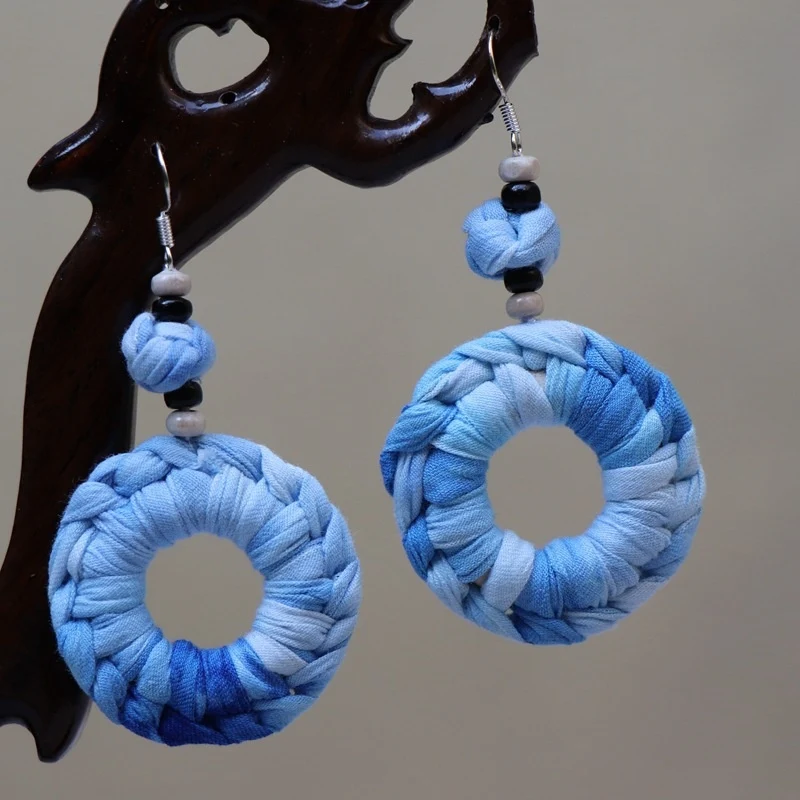 Boucles d'oreilles ethniques bleues en tissu teint à la main. Un accessoire unique et élégant, parfait pour un look bohème et sophistiqué.