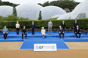 European Commission President Ursula von der Leyen, German Chancellor Angela Merkel, Japan's Prime Minister Yoshihide Suga, France's President Emmanuel Macron along with Britain's Queen Elizabeth, Canada's Prime Minister Justin Trudeau, Britain's Prime Minister Boris Johnson, Italy's Prime Minister Mario Draghi, US President Joe Biden and European Council President Charles Michel pose for a group photo on the sidelines of the G7 summit, at the Eden Project in Cornwall, Britain, on June 11 2021. 