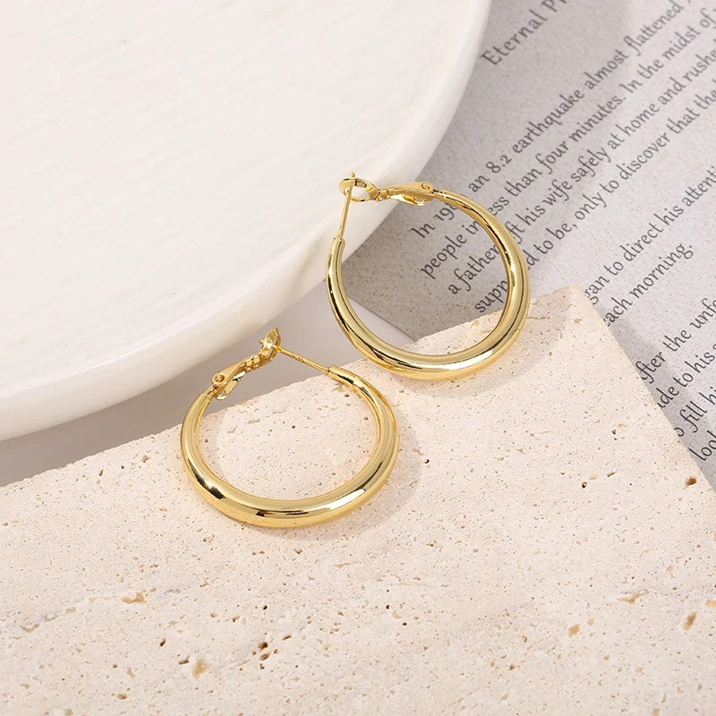 Boucles d'oreilles lisses dorées 18k en cuivre, créatives, style européen et américain exagéré, pour un look audacieux et tendance.