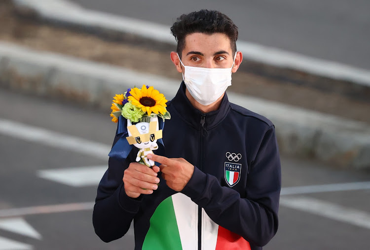 Medallist Massimo Stano of Italy wearing a face mask gestures on the podium