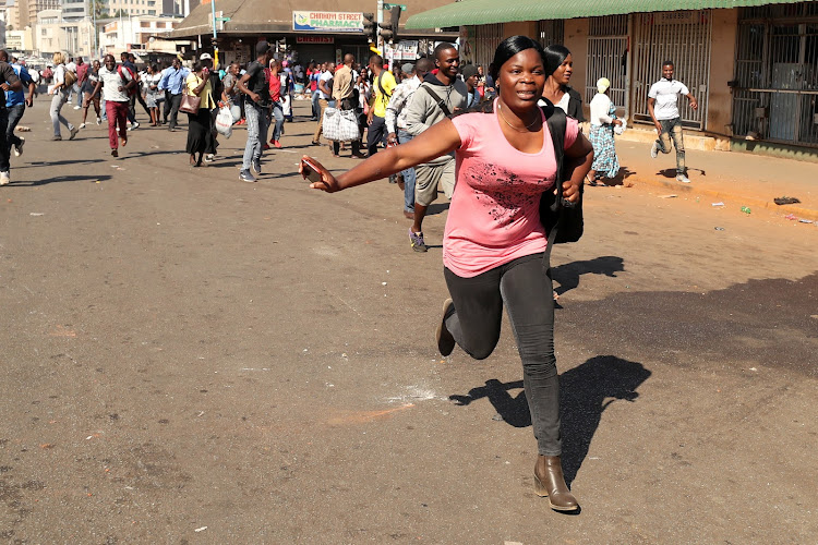 Supporters of the opposition Movement for Democratic Change flee as soldiers prepare to disperse crowds outside the party's headquarters in Harare, Zimbabwe, August 1, 2018.