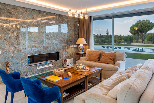 Modern living room with fireplace and pool view in this luxury house for sale in Loulé ($7,415,097)