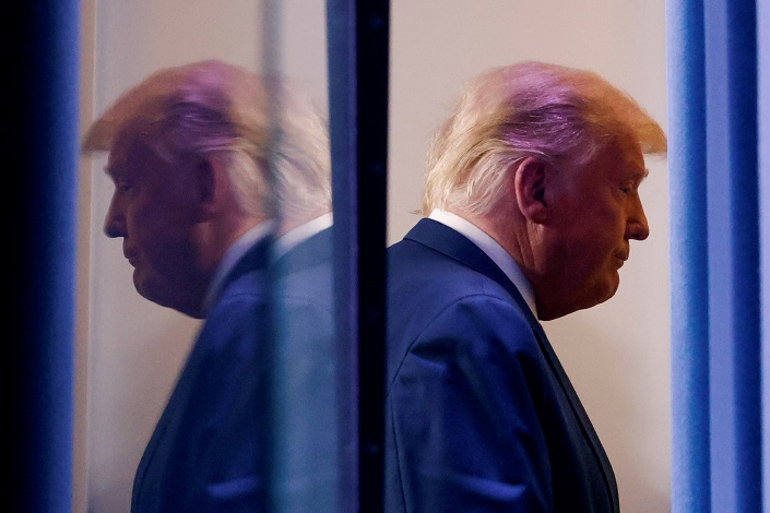 US President Donald Trump is reflected as he departs after speaking about the 2020 US presidential election results in the Brady Press Briefing Room at the White House in Washington, US, November 5, 2020.