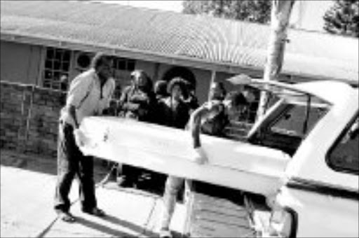 TRAGIC: Funeral undertaker workers carry the body of a woman shot dead by her estranged husband at Makhado police station. Pic. Elijar Mushiana. 28/05/08. © Sowetan.