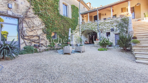 Gravel courtyard with stone house and greenery in this luxury house for sale in Uzès ($1,135,738 - 330 m²)