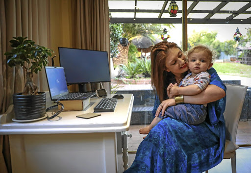 Lauren Campbell with her 15-month-old son, Daniel. She says she is looking forward to going back to her office because productivity is a challenge with a toddler to look after while she is trying to work.