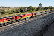 A Transnet Freight Rail train is seen next to tons of coal mined from the nearby Khanye Colliery mine, at the Bronkhorstspruit station, in Bronkhorstspruit.