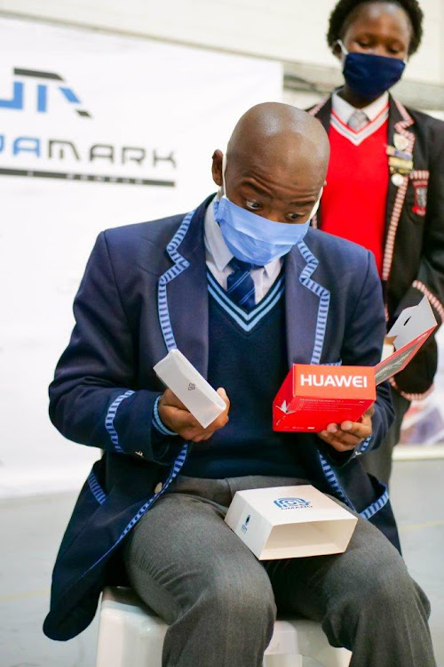 Sibusiso Gcakasi, a grade 12 pupil at Douglas Mbopa High School, unpacks his new Omang e-learning device. It is pre-loaded with textbooks and digital educational resources that will help him and his peers, like Aphiwe Gxotiwe, back, minimise the disruption to their academic year.