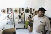 COPY CLAMPDOWN: Oupa Moloi of Risa with cassettes and confiscated equipment at a factory in Kempton Park busted for manufacturing illegal CDs, DVDs and cassettes. Pic. Veli Nhlapo. 22/11/2006. © Sunday World.
