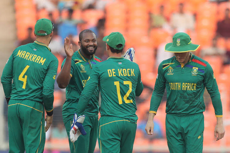 Proteas all-rounder Andile Phehlukwayo (smiling) celebrates the wicket of Afghanistan's Rashid Khan during the 2023 ICC men's Cricket World Cup match.