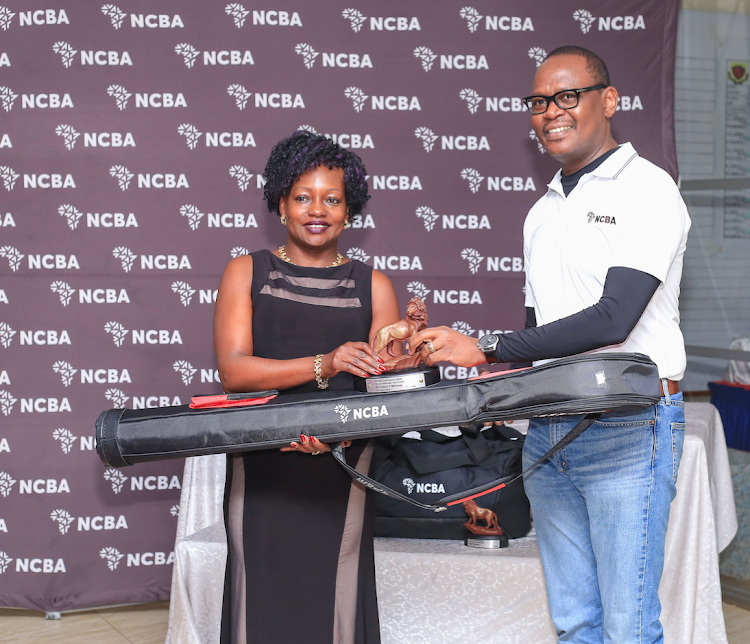 Royal Nairobi Golf Club's Lucy Kisia receives her NCBA Golf Series Division One winner's prize from NCBA's Lennox Mugambi