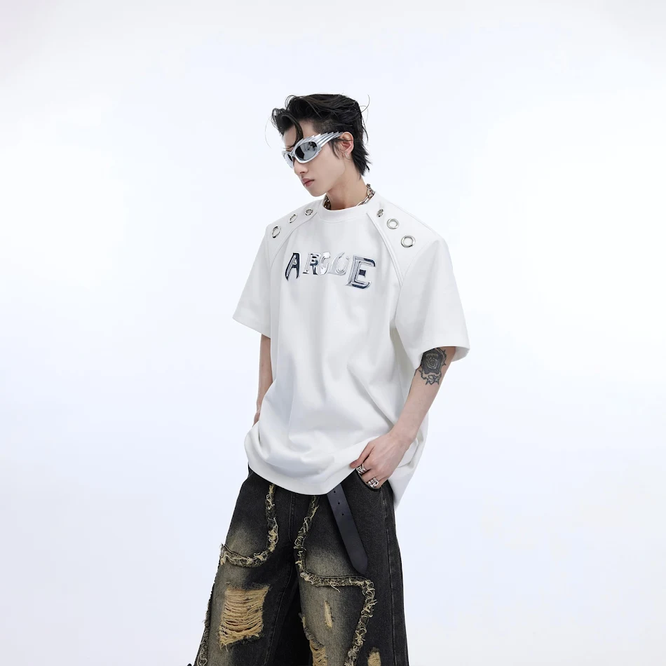 T-shirt sciolto a maniche corte con spalline imbottite e design con anelli metallici, perfetto per un look casual e alla moda.