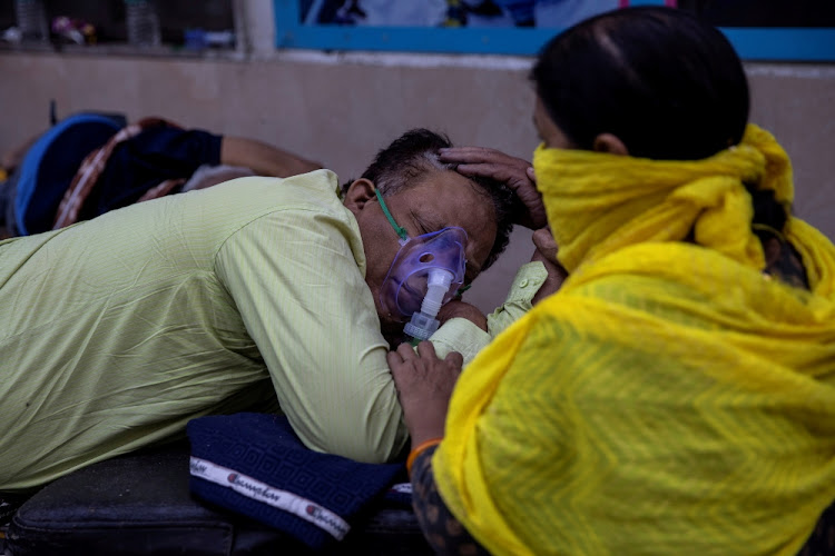 A woman takes care of her husband who is suffering from Covid-19 as he waits to get admitted outside the casualty ward at Guru Teg Bahadur hospital amid the spread of the disease in New Delhi, India on April 23 2021.