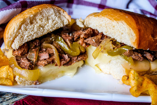 Our Family Crock Pot Philly Cheesesteak Sandwich on a plate with chips.