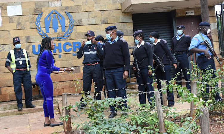 A woman confronts police officers outside UNHCR offices after a refugee committed suicide outside the outside the offices on April 13, 2020