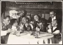 feestende, half dronken, groep mannen rond een tafel