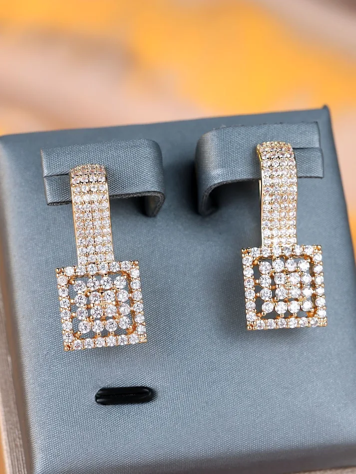 Boucles d'oreilles carrées en or champagne, diamants blancs ronds. Un éclat luxueux pour sublimer votre visage et illuminer vos tenues.