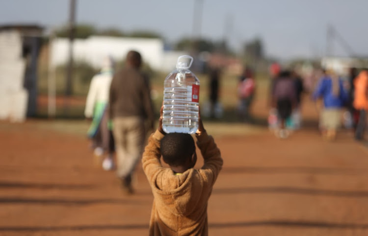 A child collects water in Hammanskraal during a deadly cholera outbreak earlier this year.