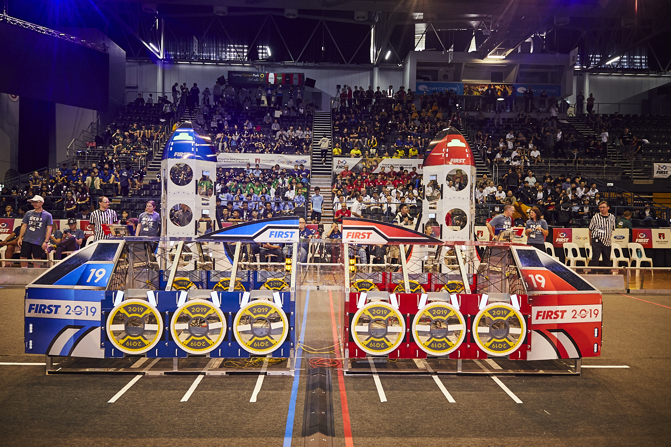 Photo of  large contraption at the FIRST Regional Robotics Competition at Sydney Olympic Park, with attendees in the background