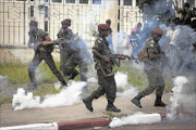 CAUGHT IN CROSSFIRE:  Members of the presidential guard are caught in teargas fired by police at a crowd of opposition 
      supporters outside N'Djili Airport in the DRC
       capital Kinshasa
      . Police 
       blocked President Joseph Kabila's main rival at an airport in 
       the city on Saturday to stop him staging an election rally after at least two people 
       were killed in violence across the 
       country's capital city. 
      Photo: REUTERS