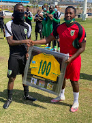 Nduduzo Sibiya accepts a 100th cap memento from Arrows assistant coach Mabhuti Khenyeza