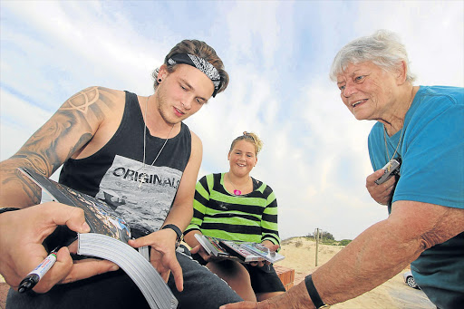 DEVINE INSPIRATION: One Direction drummer Josh Devine shows his grandmother Kathy Clayton a picture of himself jamming with the band while Port Alfred super-fan Nakita Avis patiently waits for him to autograph a book Picture: DAVID MACGREGOR