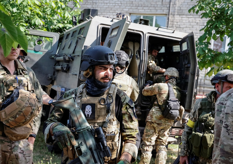 Members of a foreign volunteers unit which fights in the Ukrainian army stand near a vehicle as Russia's attack on Ukraine continues in Sievierodonetsk, Luhansk region, Ukraine, on June 2 2022.