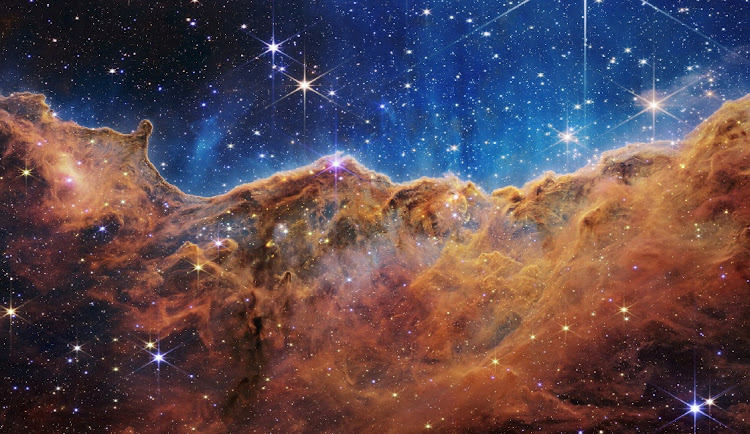 The 'Cosmic Cliffs' of the Carina Nebula in an image from Nasa's James Webb Space Telescope, a revolutionary apparatus designed to peer through the cosmos to the dawn of the universe.